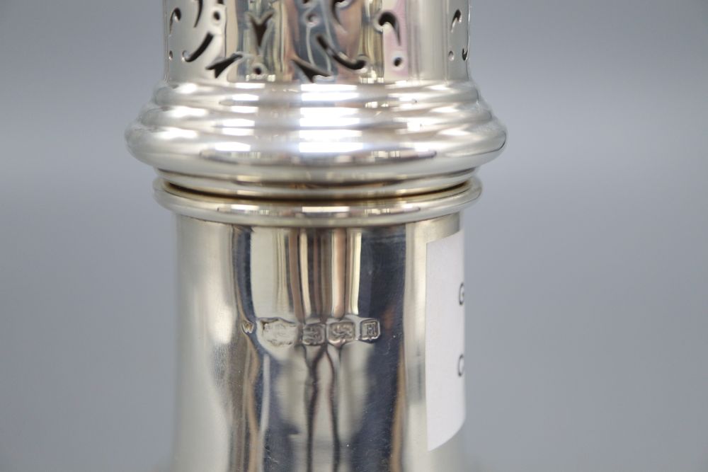 A silver vase shape sugar shaker, with pierced domed cover, ribbed finial on circular base, Birmingham 1932, 7.6oz., height 23cm